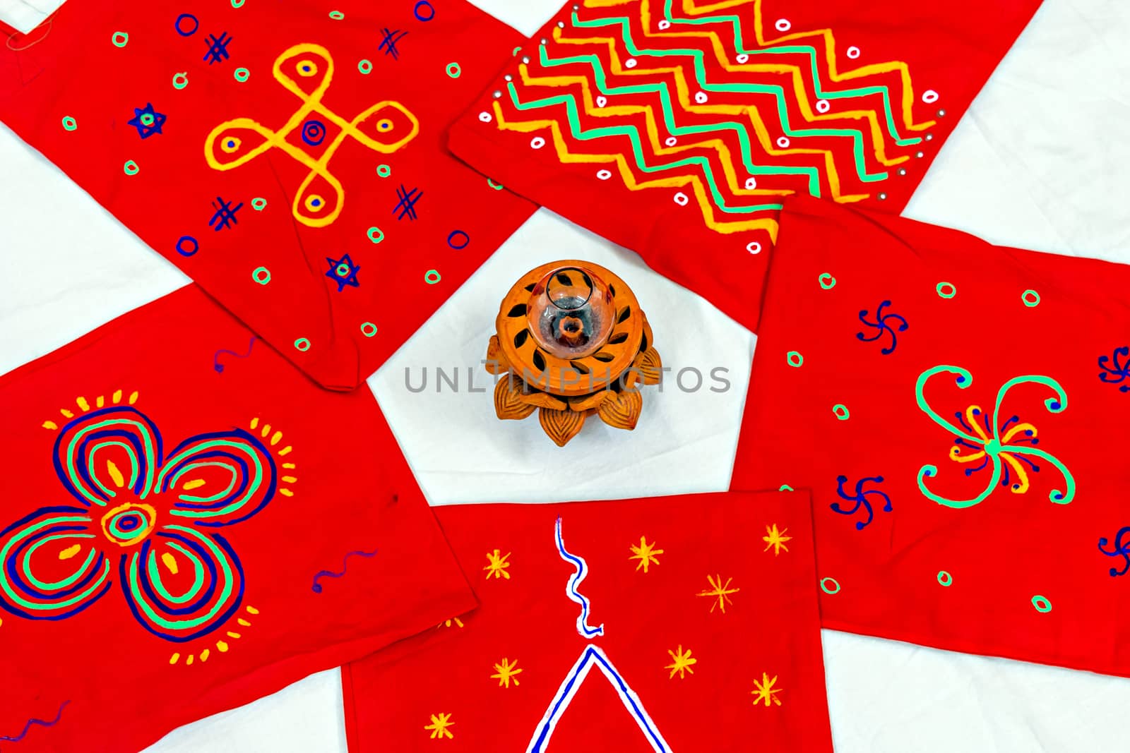 Bright red Colored cotton bags with hand painted symbols & diya arranged in pattern. Can be used as background.