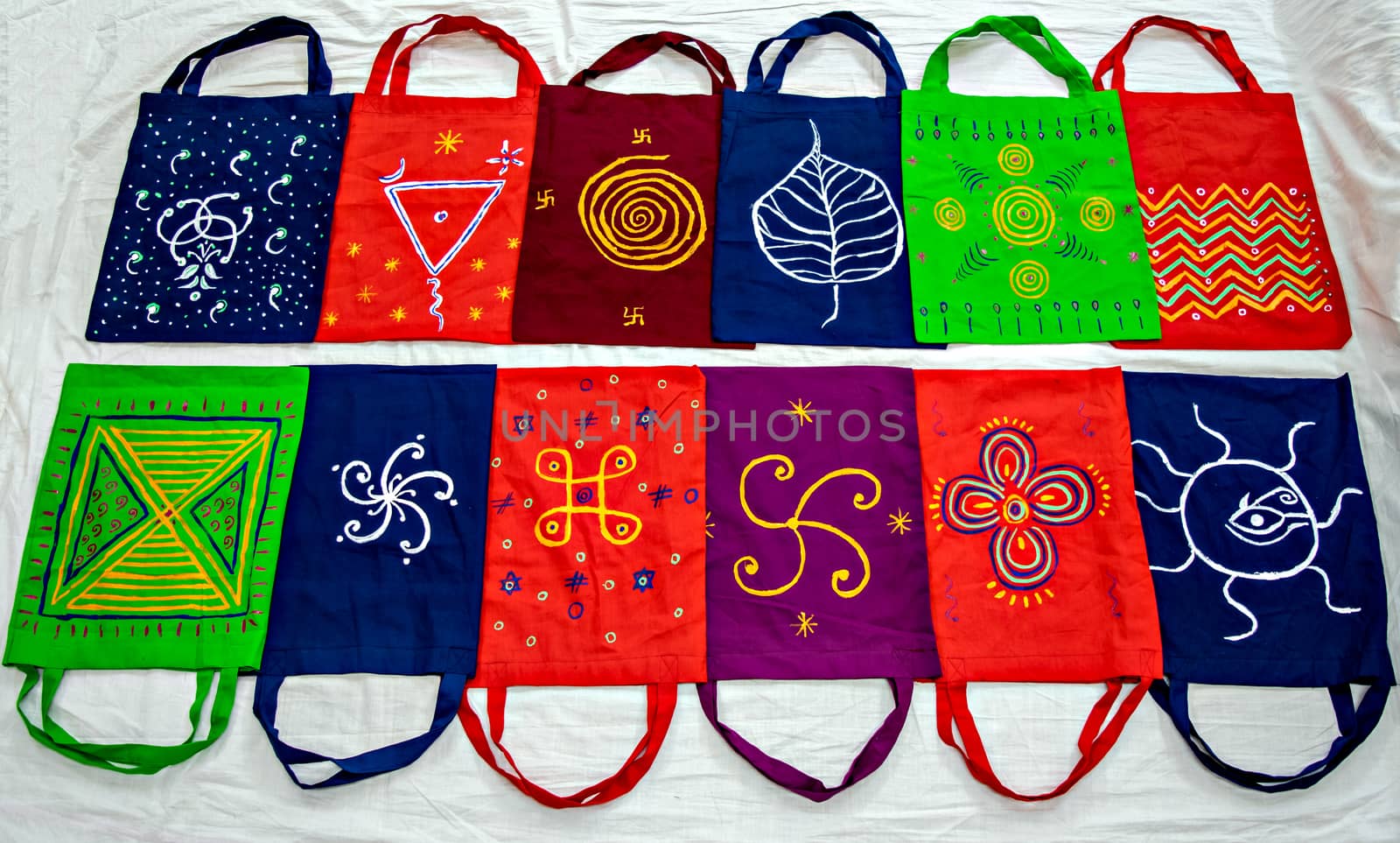 Colorful cotton bags with hand painted symbols arranged in pattern. by lalam