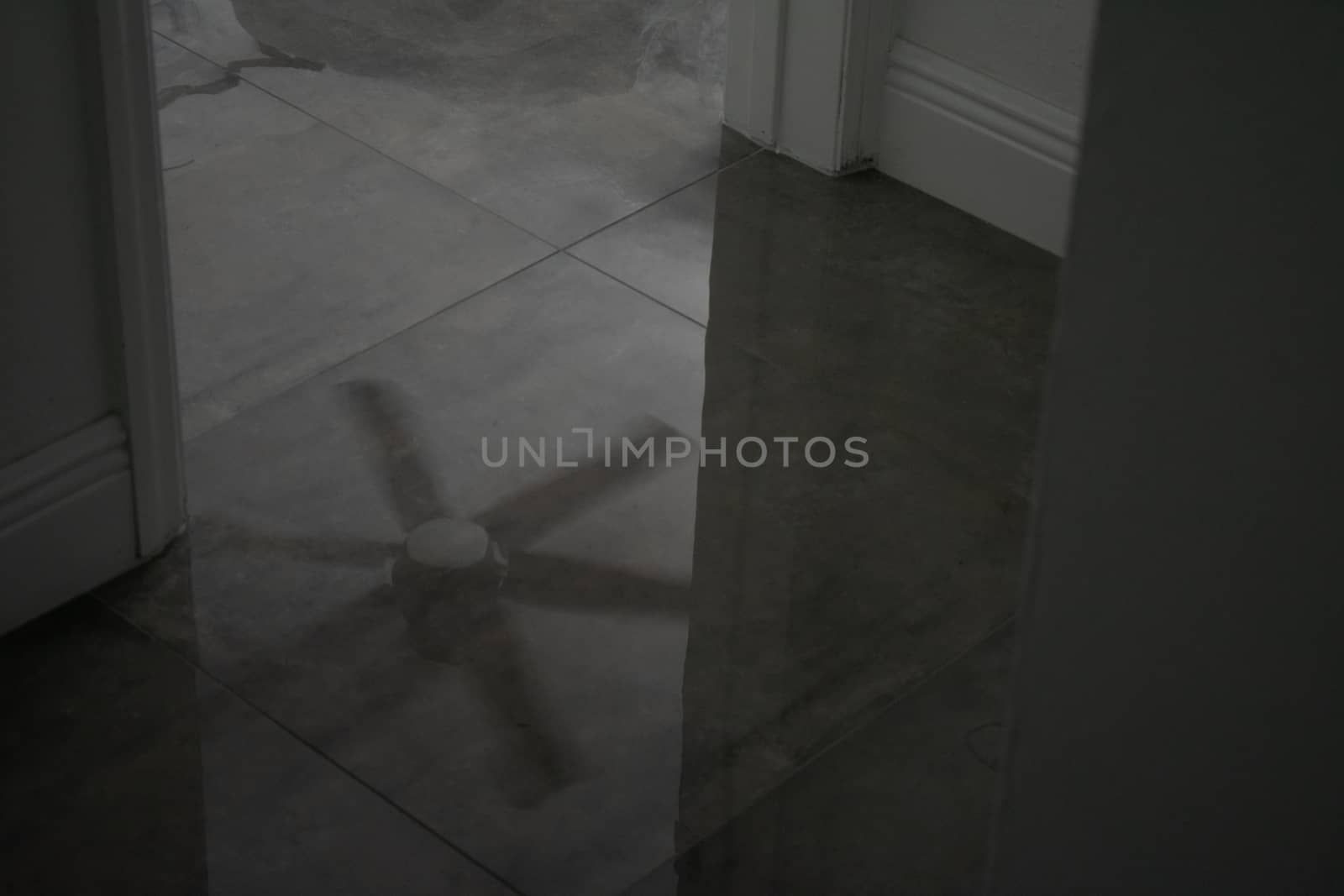 A Spinning Ceiling Fan Reflecting off a Marble Floor by bju12290