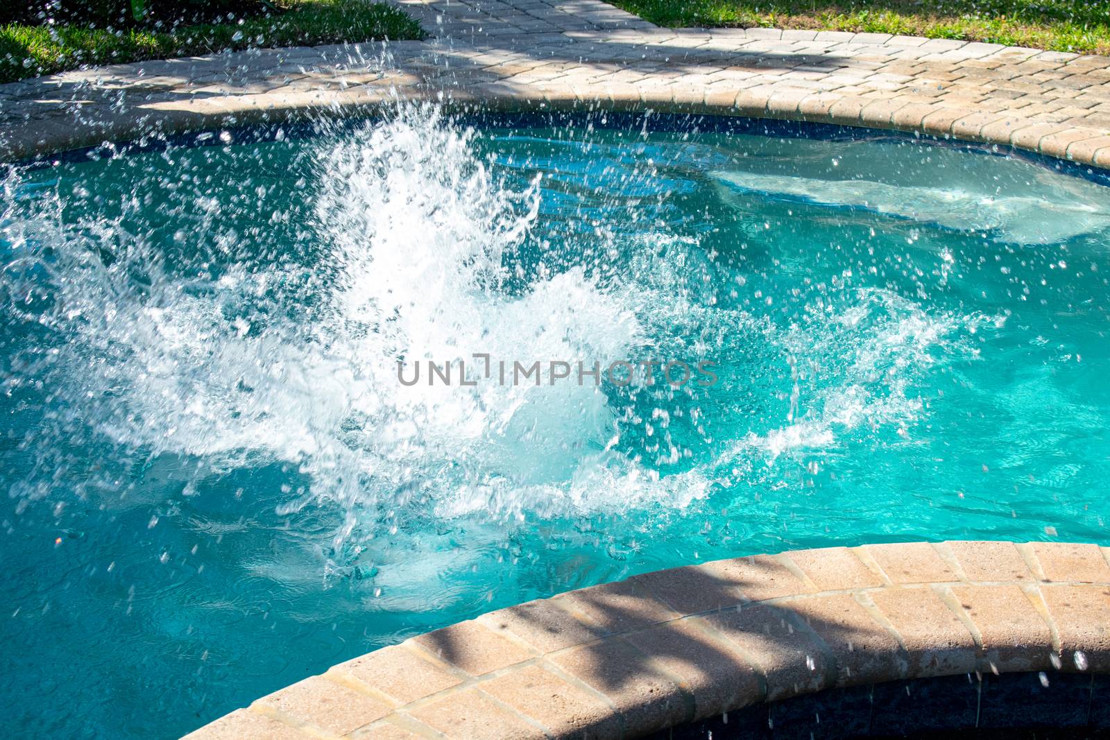 A Splash in a Pool Caused By a Boy Jumping Into the Water by bju12290