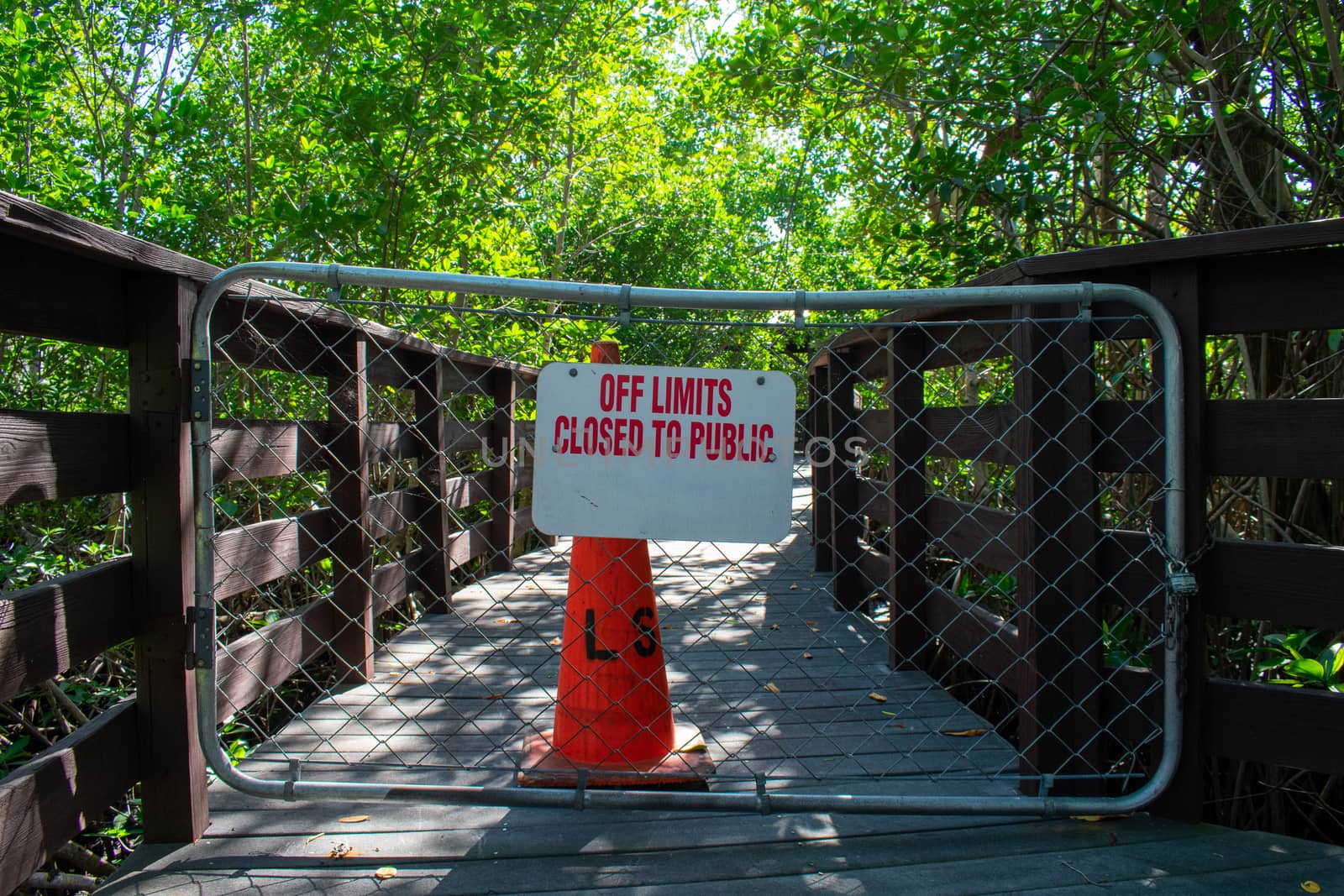 A Boardwalk With a Fenced Off Section With a Sign Stating That I by bju12290