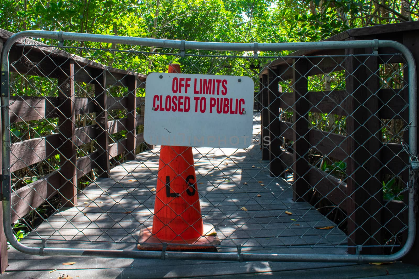 A Boardwalk With a Fenced Off Section With a Traffic Cone Behind It Stating That It's Off Limits to the Public