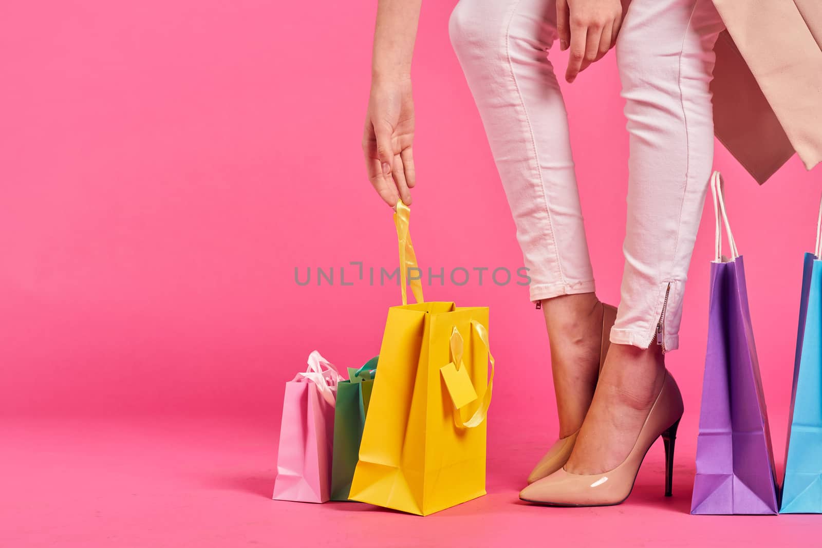 shopping bags female feet in shoes Shopaholic pink background by SHOTPRIME