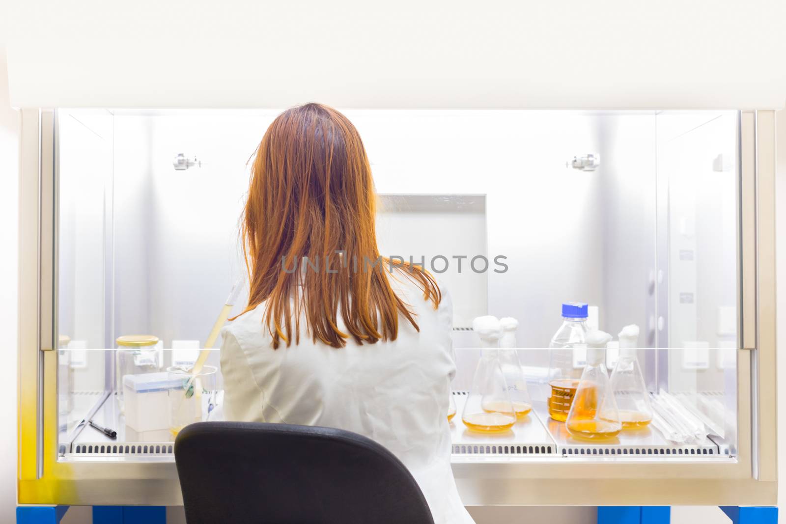 Female scientist researching in life science corona virus vaccine development laboratory by kasto