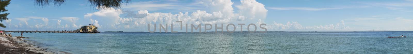 Anna Maria Island, FL, USA – July 21, 2017: The popular Rod & Reel wooden Pier stretching out into the Gulf of Mexico with the Sunshine Skyway in background from Anna Maria Island in Florida