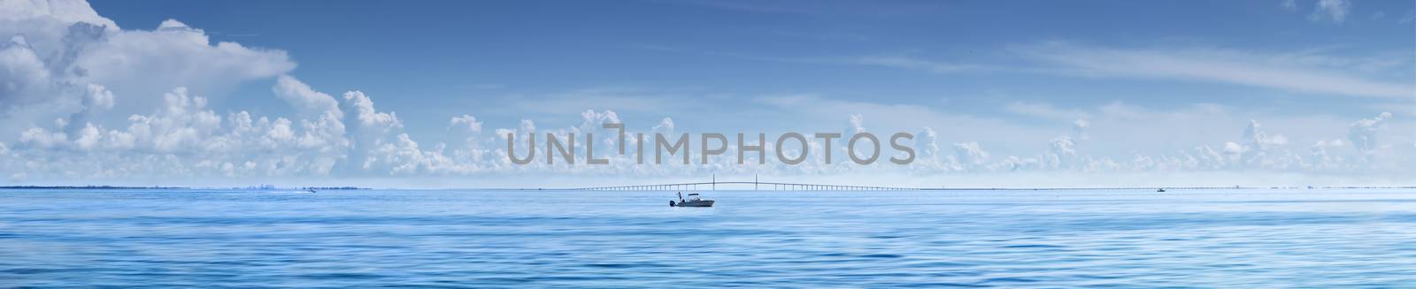 Man fishing from boat with Sunshine Skyway Bridge,Florida in Background