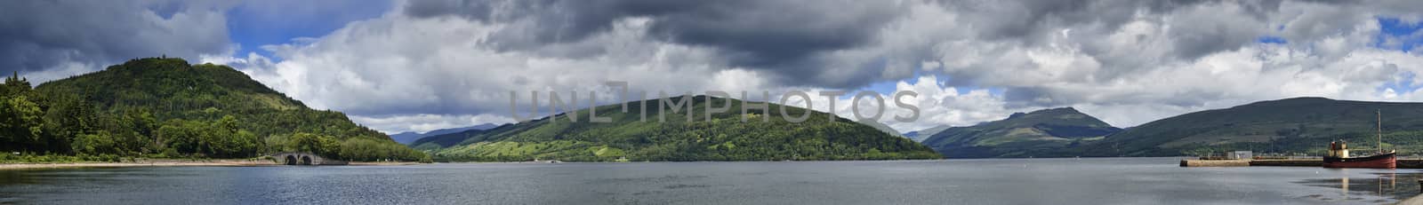 Panoramic view from Inveraray of Loch Fyne with boat moored in harbour and hills in background