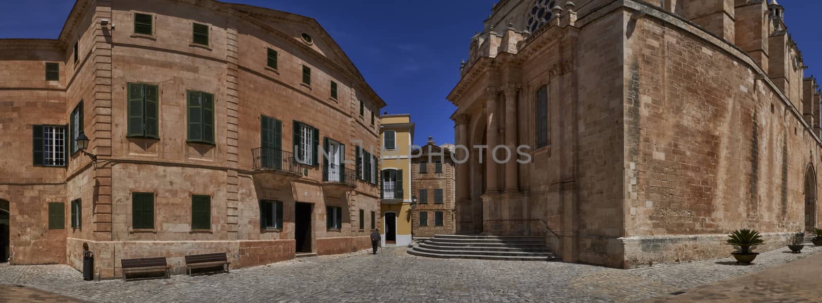 Panoramic view of old man with walking stick walking passed entrance to Cathedral in Ciutadella, Menorca