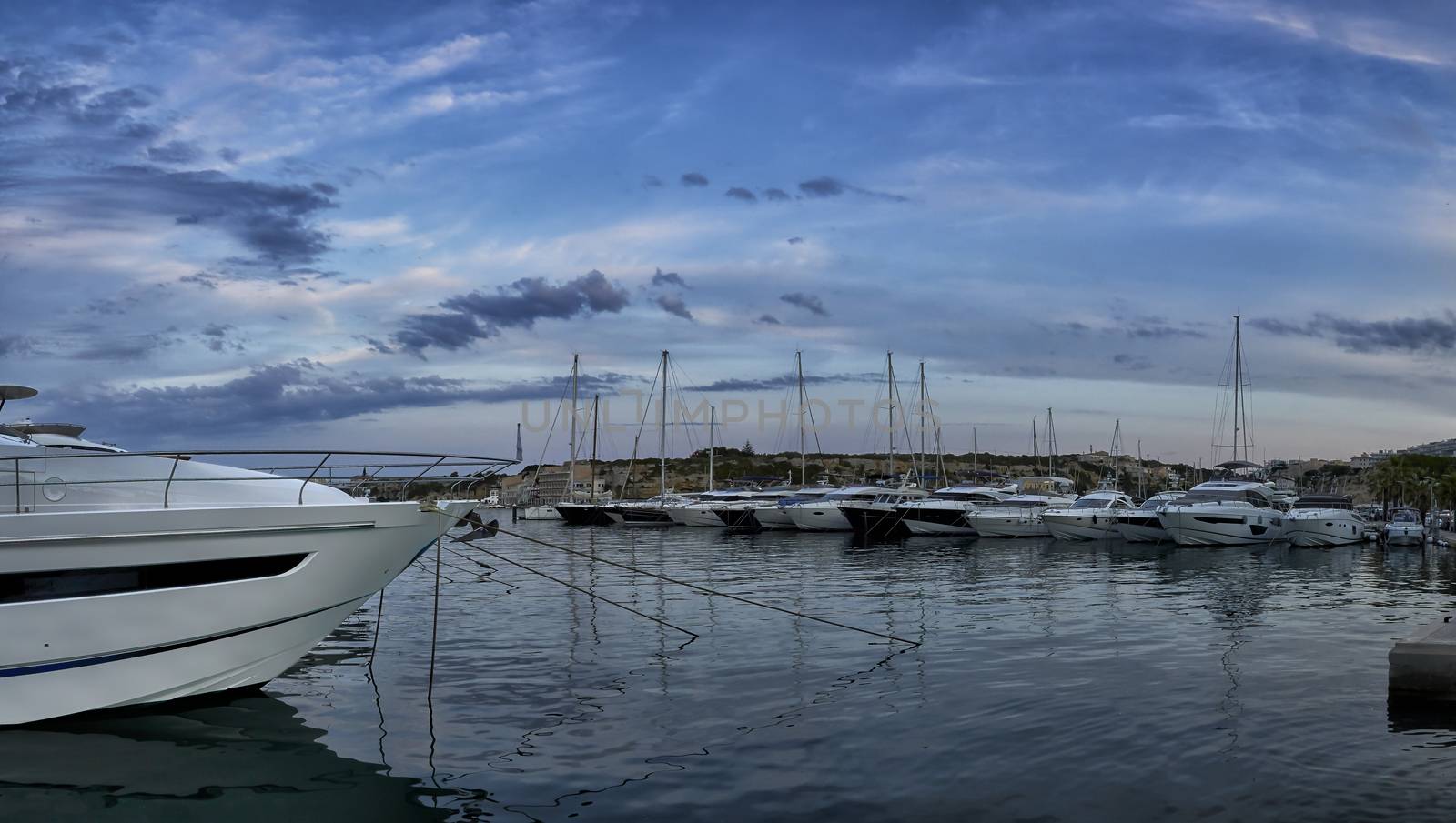 Panorama of luxury boats moored in harbour at dusk