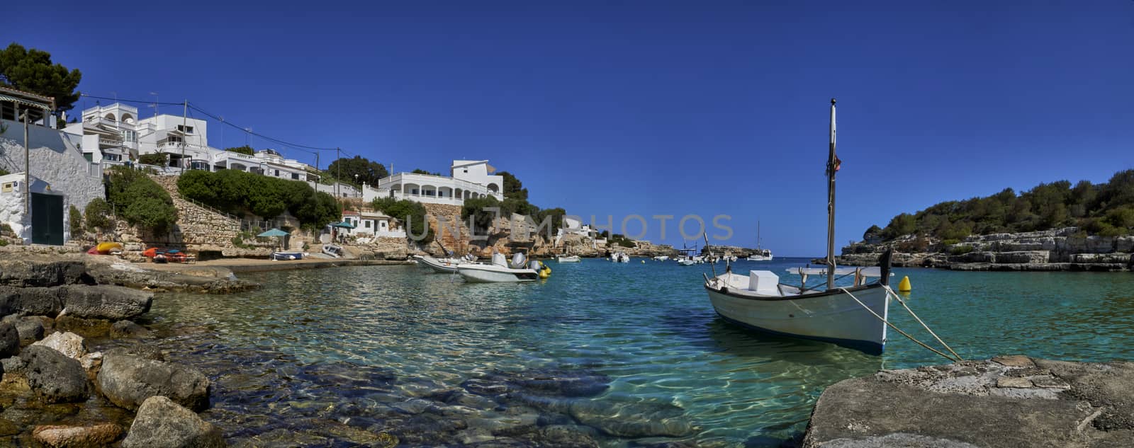 Panorama of small boats moored in the Mediterranean cove of Cala Alcaufar,Menorca,