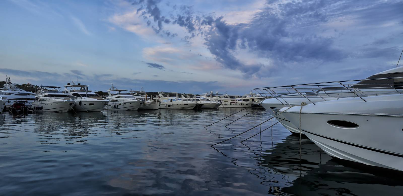 Panorama of luxury boats moored in harbour at dusk