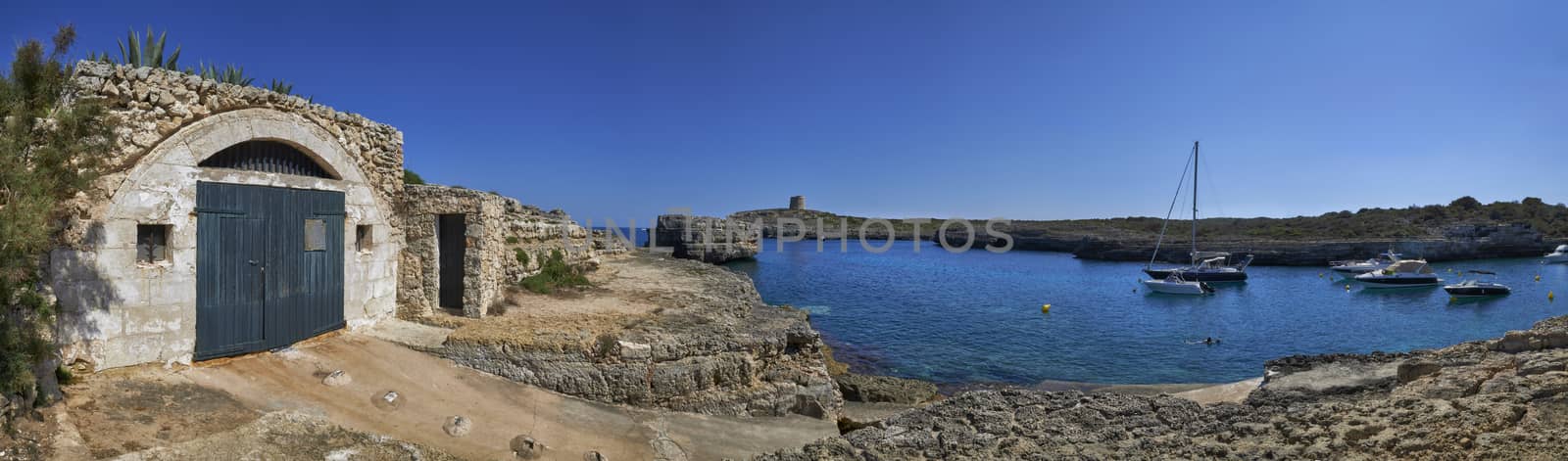 Panorama of small boats moored in the Mediterranean cove of Cala Alcaufar,Menorca,