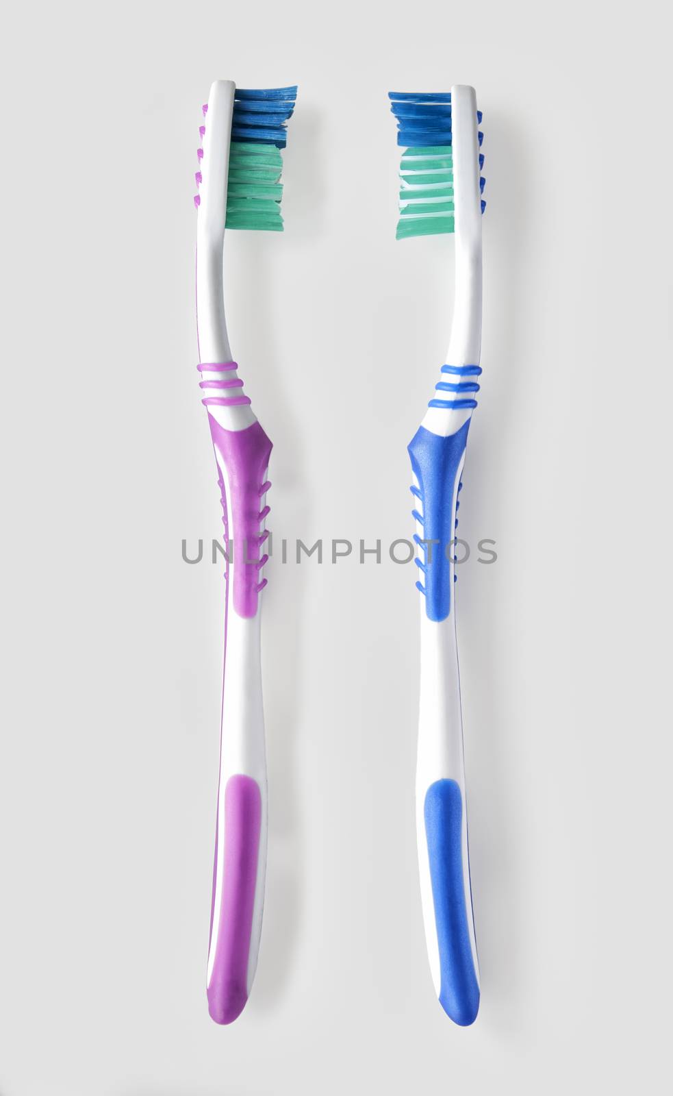 Overhead view of his and hers toothbrush on white bacground