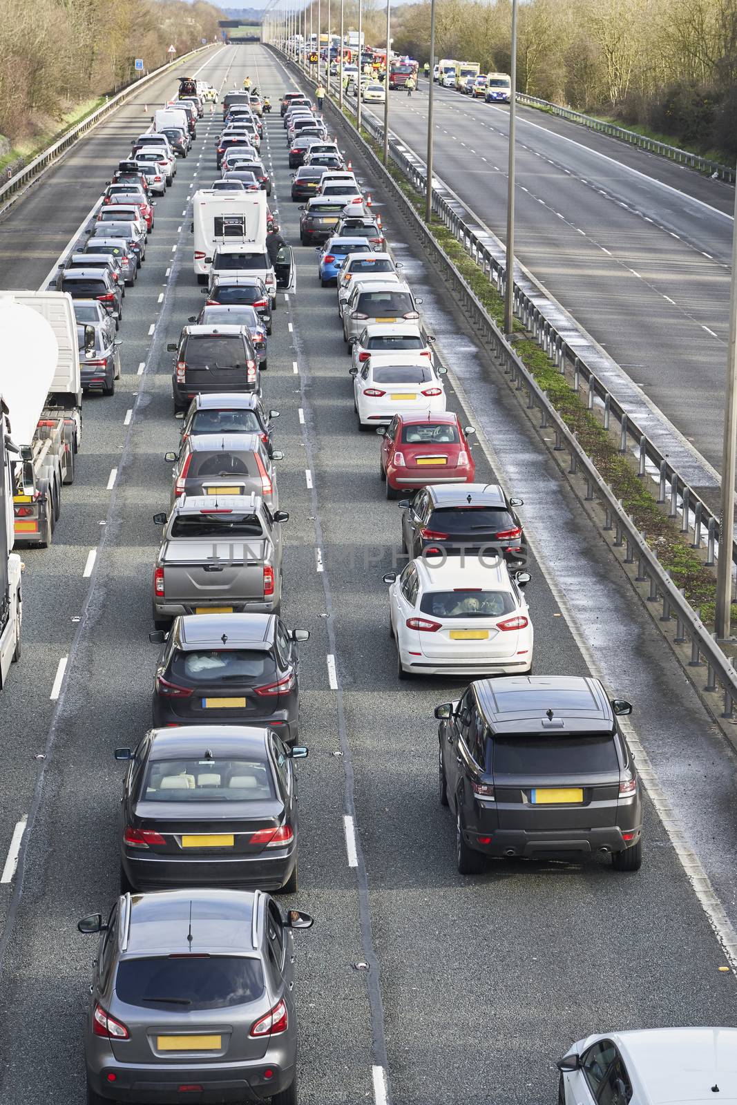 Emergency services closing motorway to attend accident causing a traffic jam