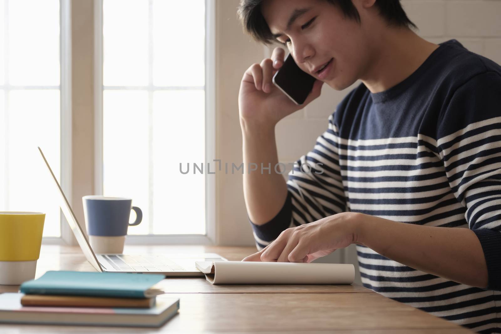 Happy young man learn language listen lecture watch webinar write notes look at laptop sit in home, distant education.