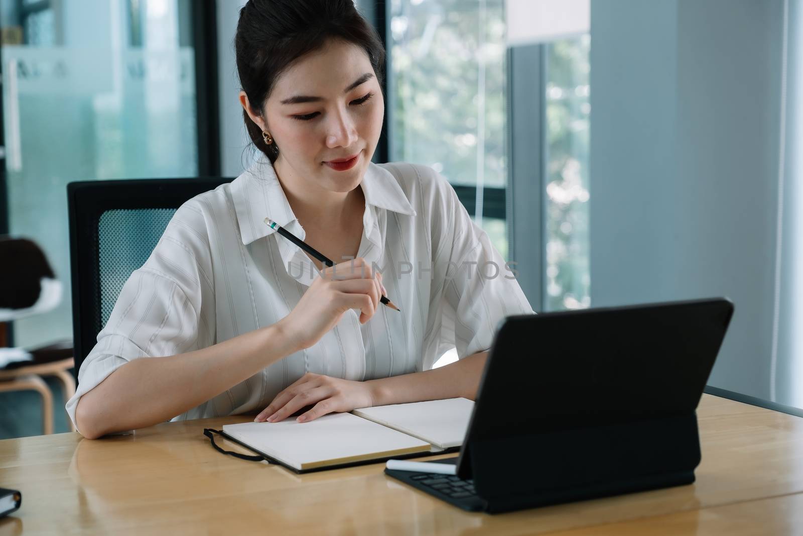 Woman using smart tablet for training online and writing lecture note. e-learning education concept.