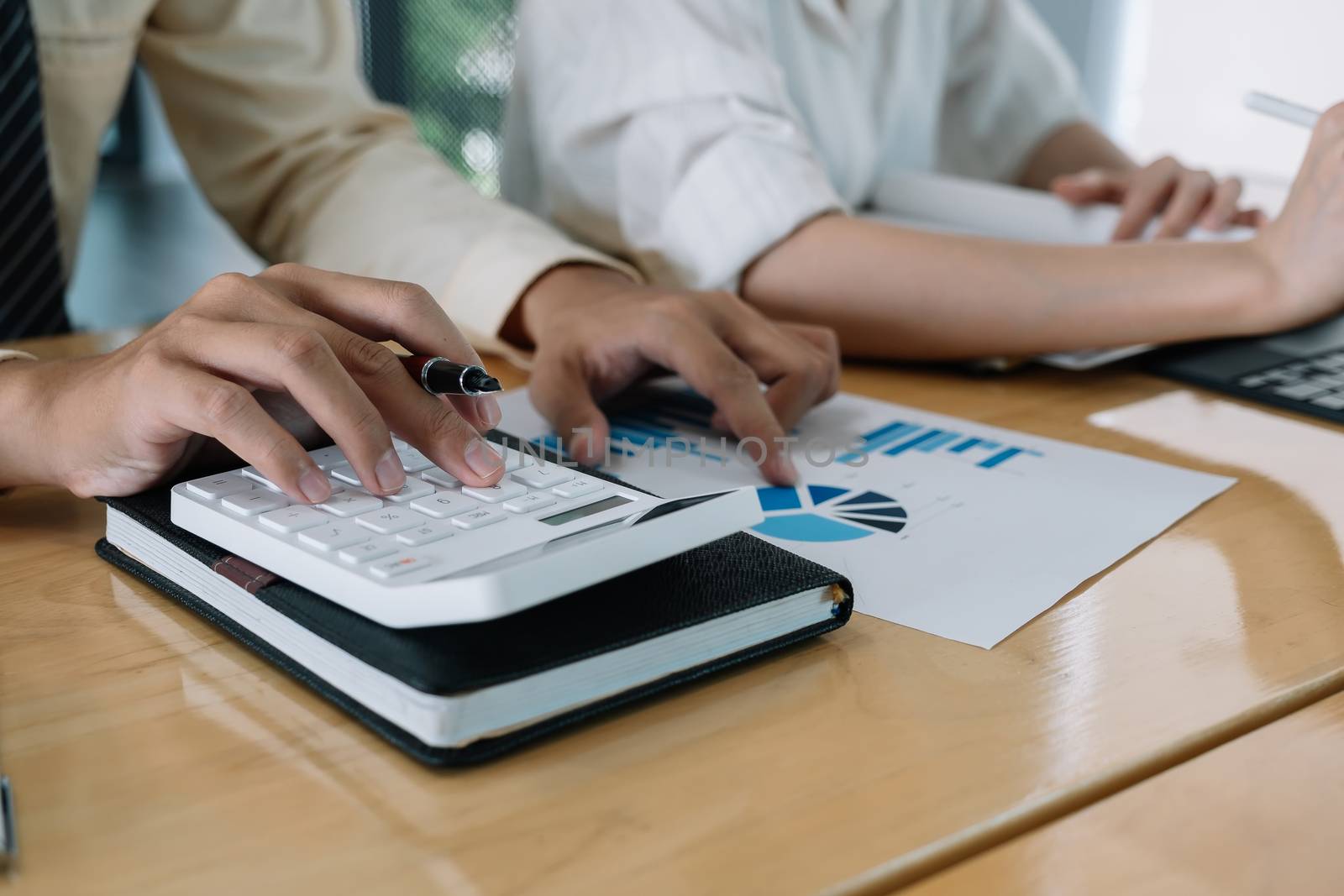 Businessman using calculator for do math finance on wooden desk in office and business working background, tax, accounting, statistics and analytic research concept.