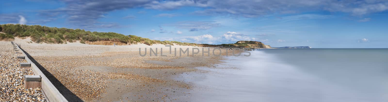 Panoramic view of Hengistbury Head beach, Dorset with groyne in the foreground and Isle of Wright Needles in background