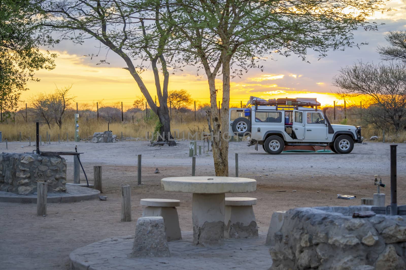 camping scene in Namibia, Africa during sunset, with 4x4, preparing to set camp for the night. by kb79