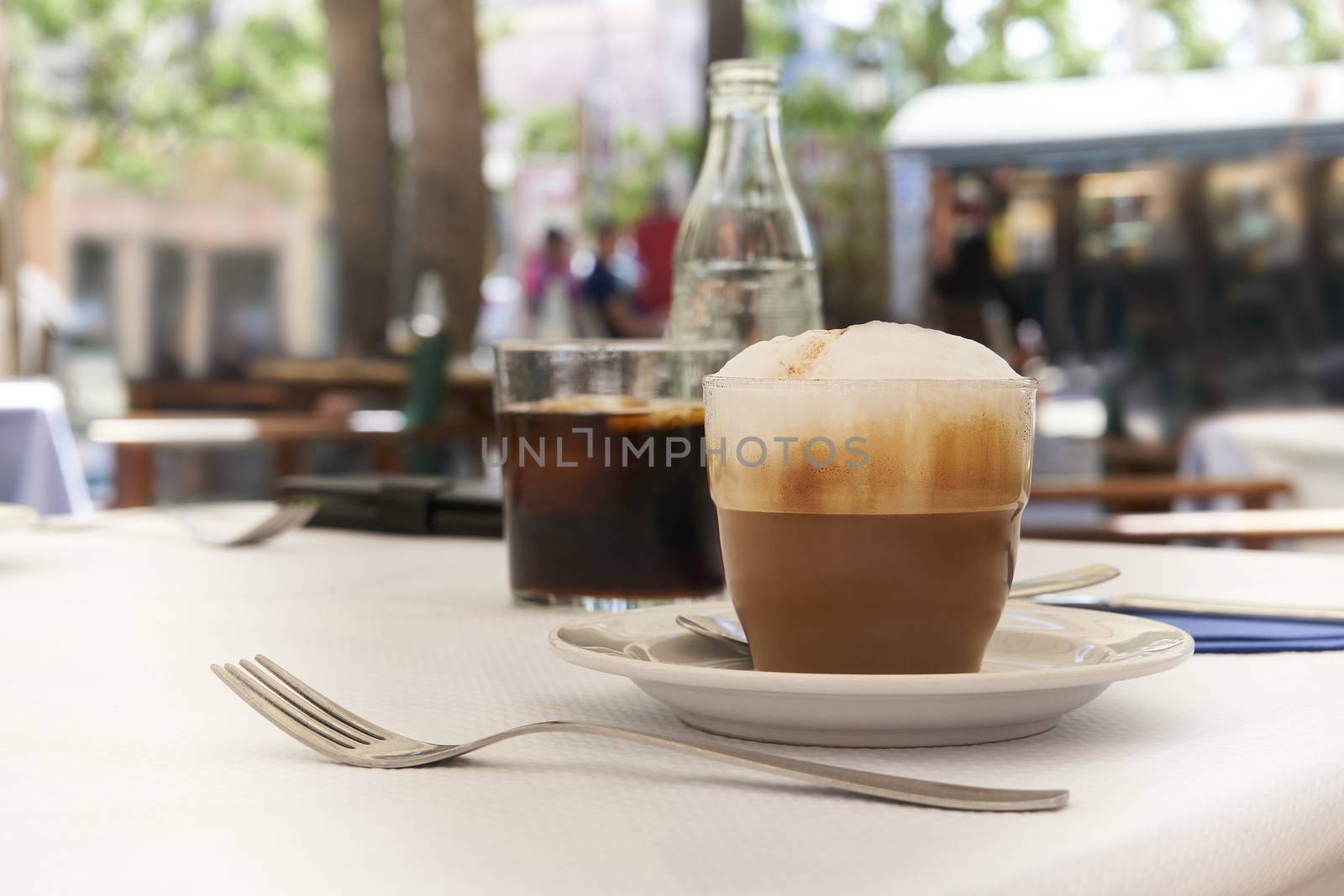 Close-up of cup of cappuccino on table in Mediterranean cafe with blurred background