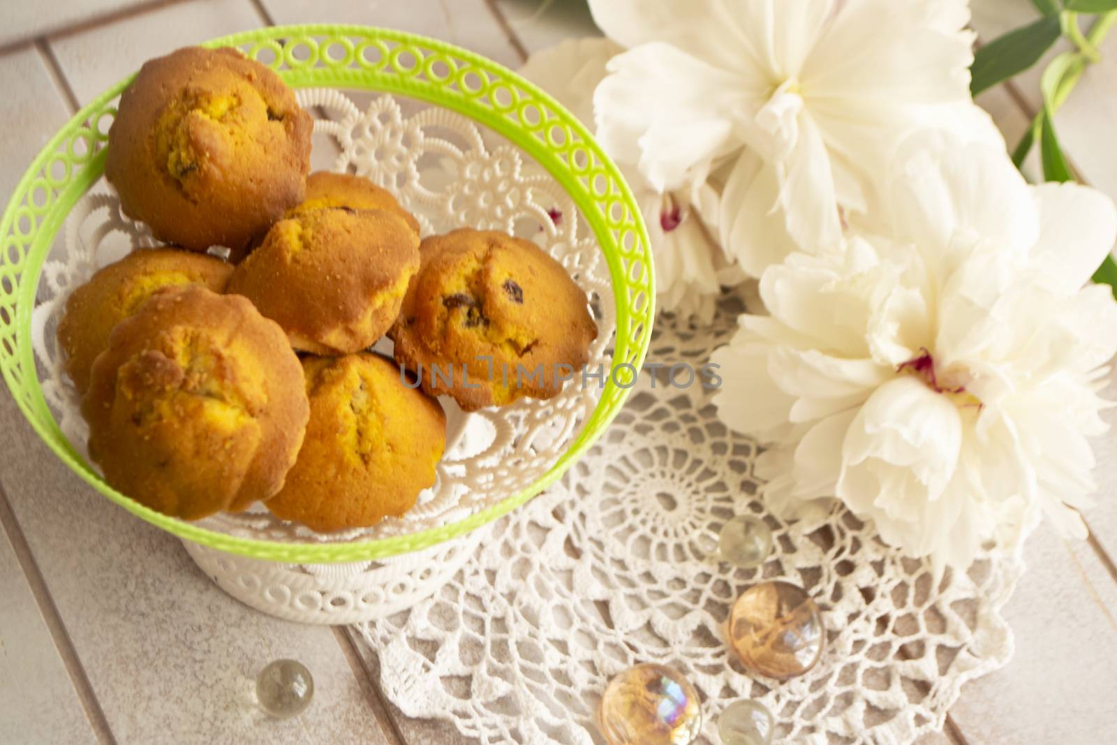 homemade muffins . Bakery products with white peony. tasty little cupcakes with flowers on wooden shabby table