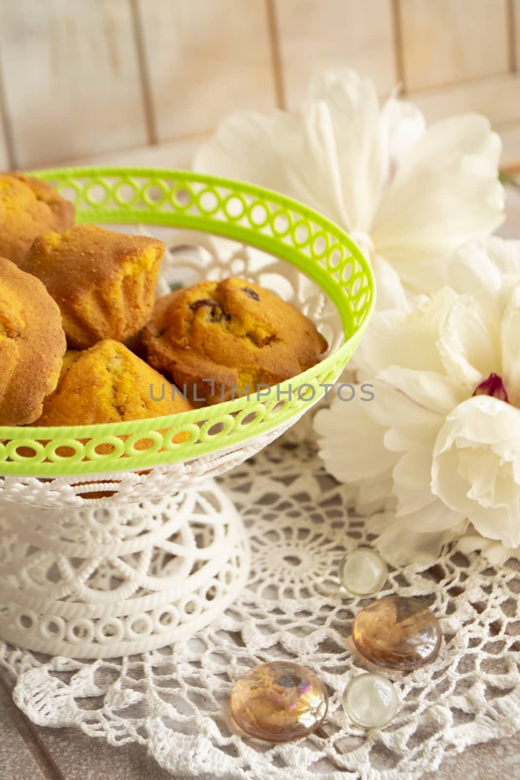 Homemade muffins and white peony flowers bouquet on lacy background. Spring, Easter, celebration concept. Tasty dessert. Vertical image