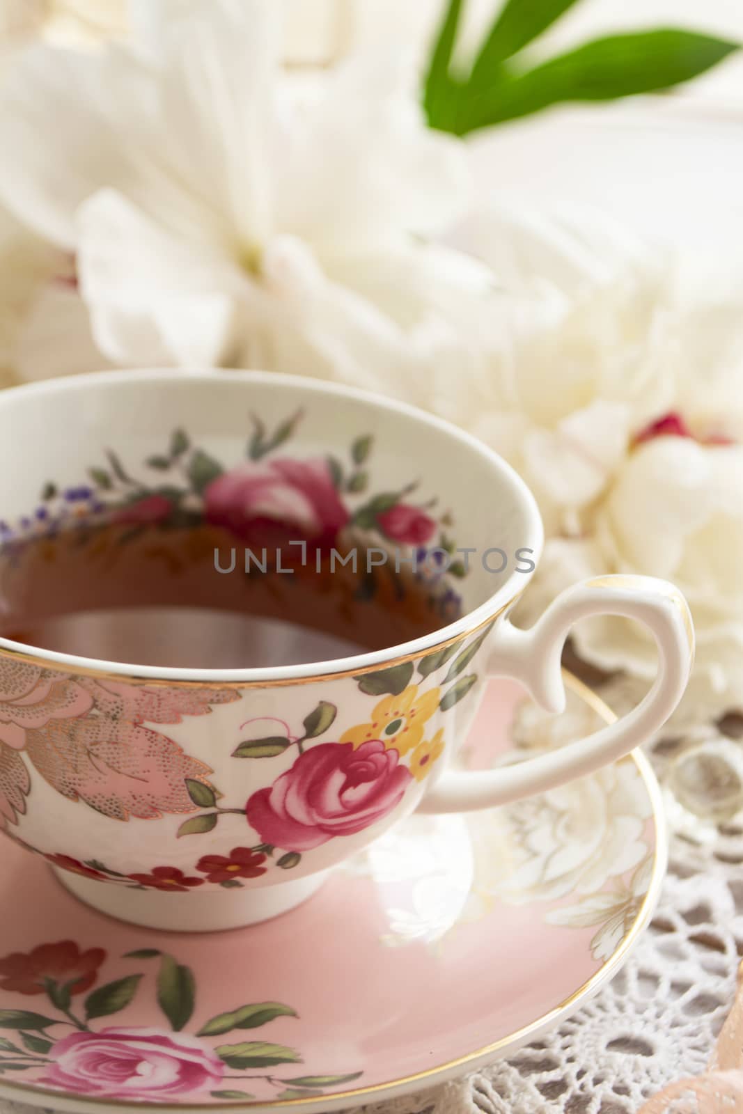 Tea time. Vintage cup of tea on a beautifully decorated table. Vertical image