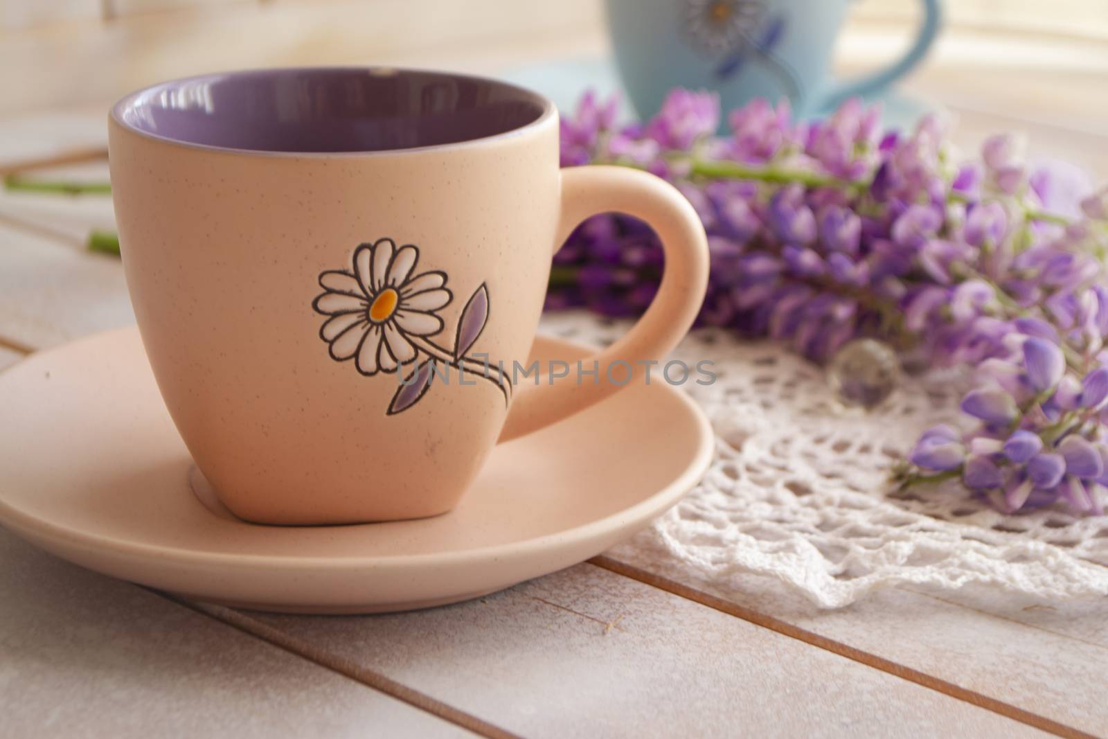 cup with coffee and pink purple lupine flowers. Lupine with long stem. Aroma and good morning concept. Lifestyle