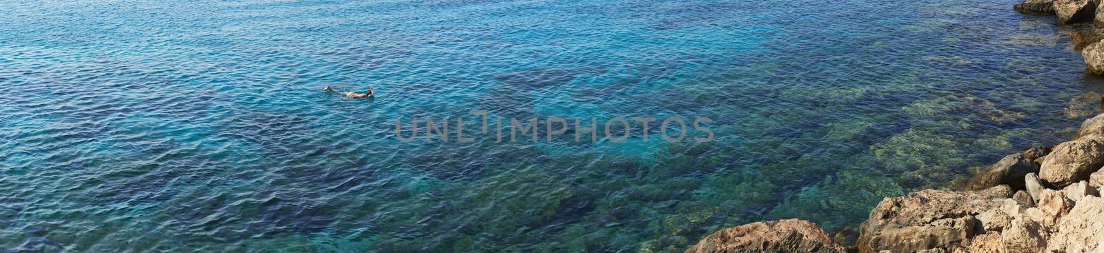 Panoramic photograph of child snorkeling in Mediterranean sea 