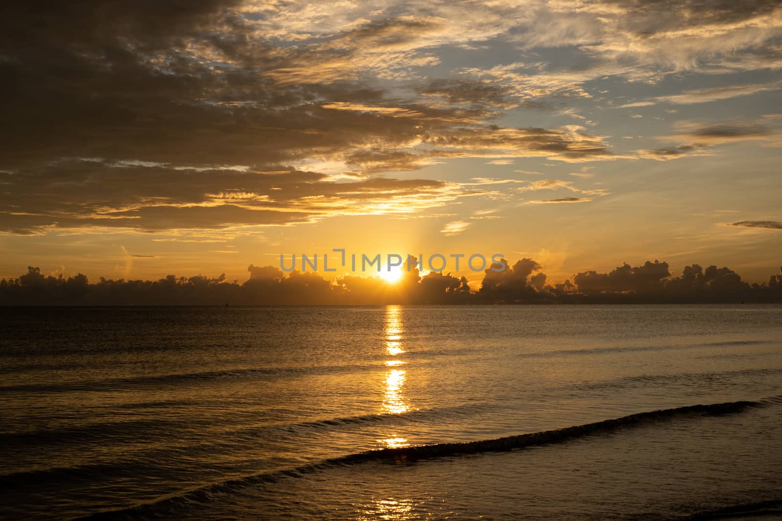 Sunrise shot over the sea and beautiful cloud. sun disappeared behind a big cloud over ocean.