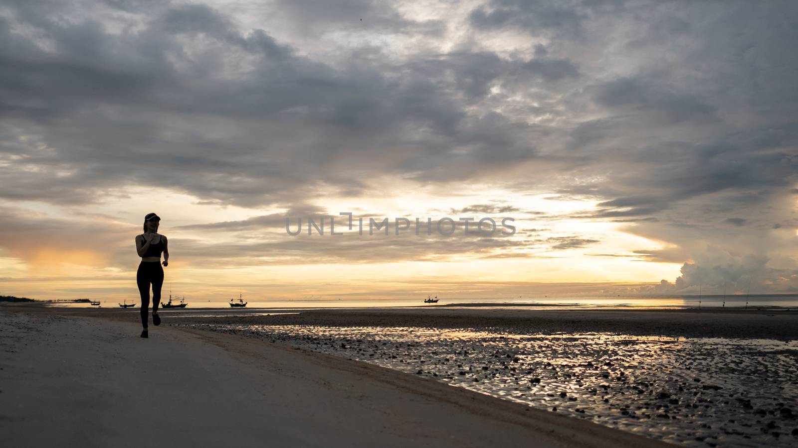 Woman jogging on beach in the morning.