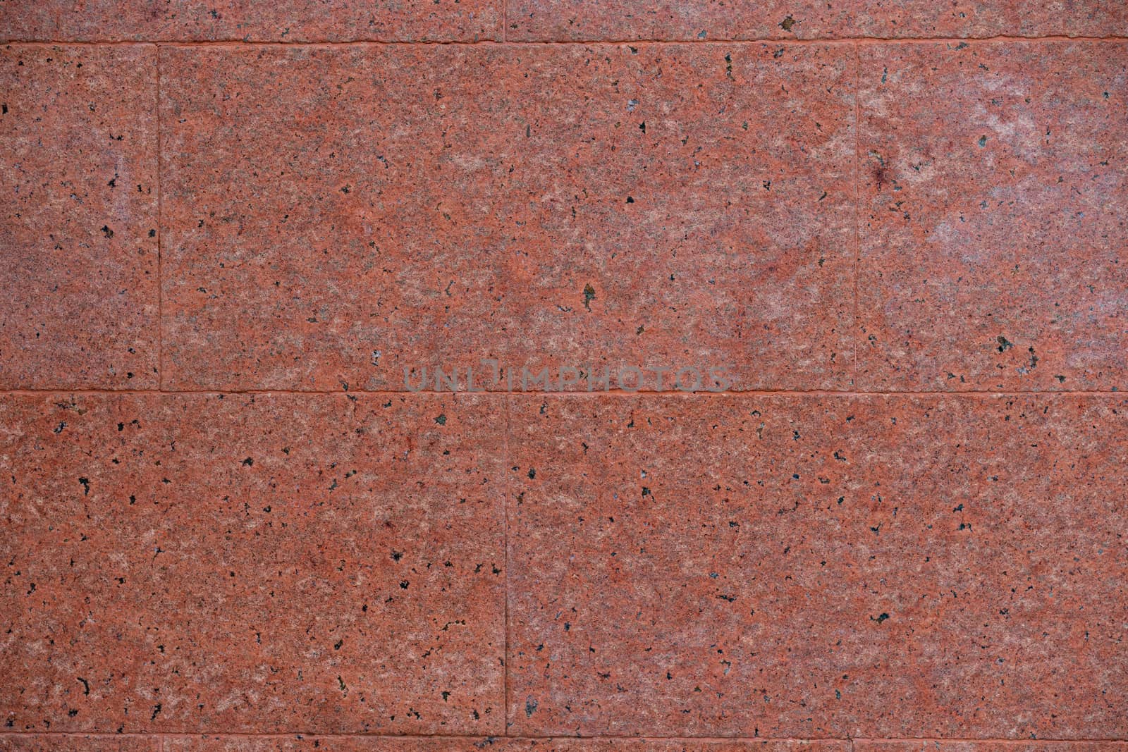 Wall texture decorative with black and white stone in pink concrete cement wall.