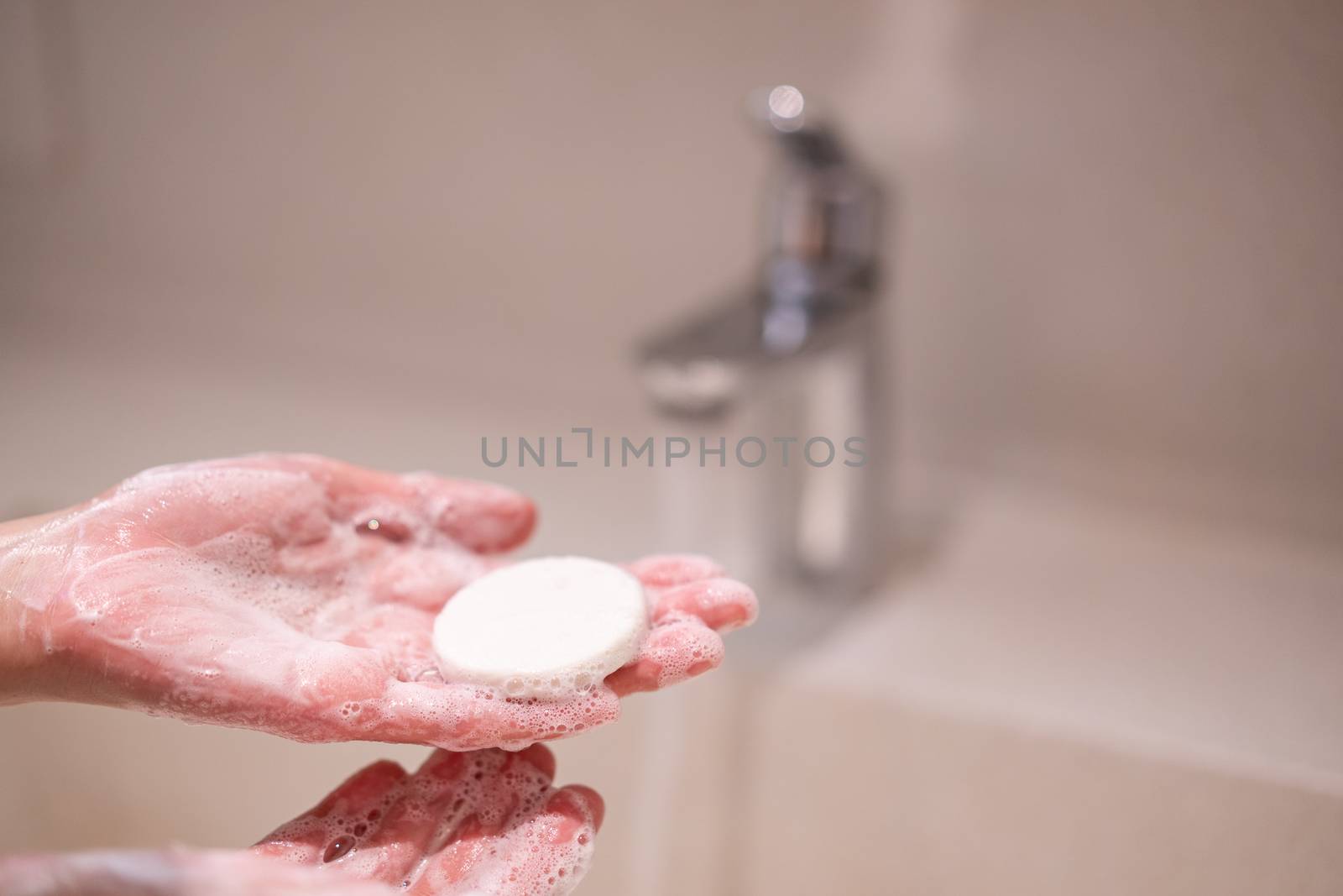 Woman use soap washing hands under the water tap.