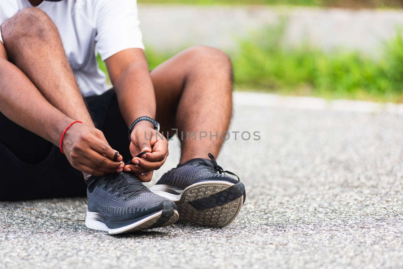 sport runner black man wear watch sitting he trying shoelace run by Sorapop