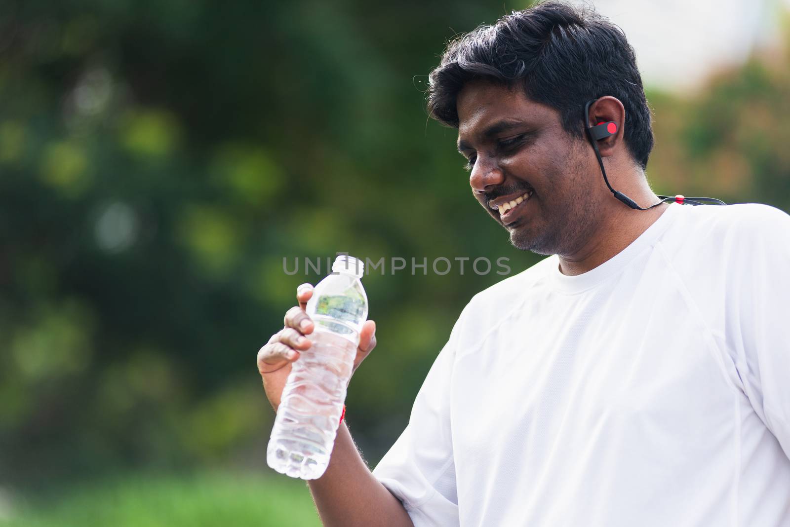 sport runner black man wear athlete headphones he drinking water by Sorapop