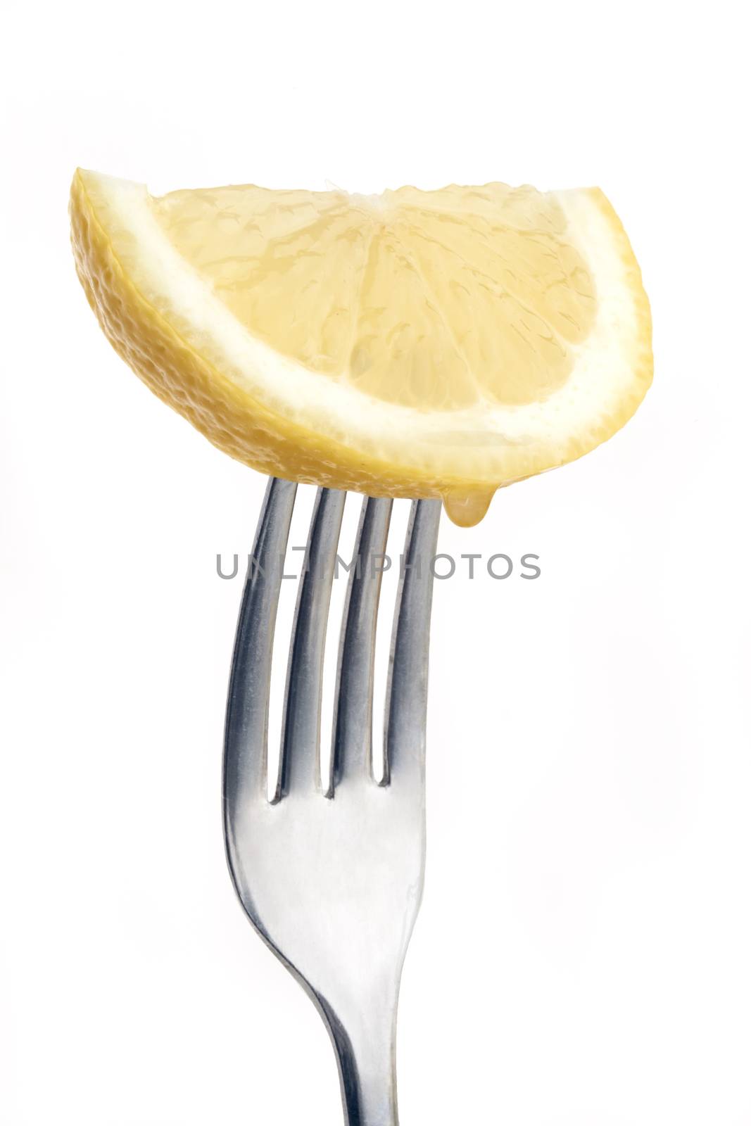 slice of lemon pierced on a fork against plain background