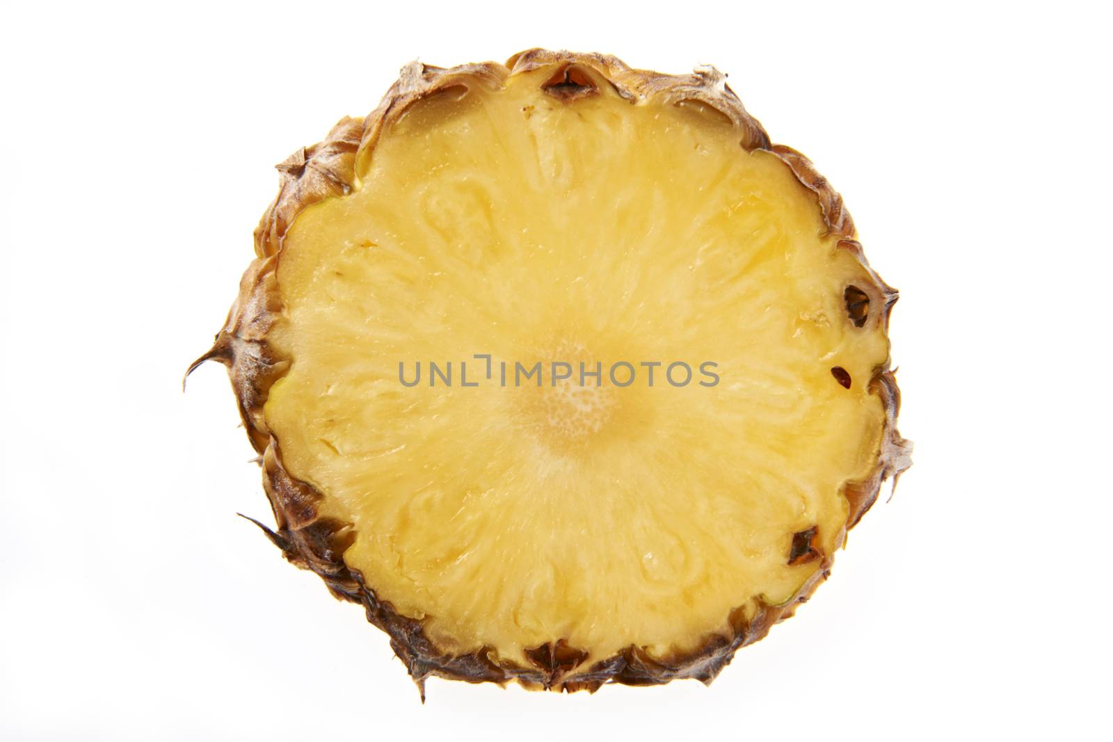 Overhead view of slice of pineapple on plain background