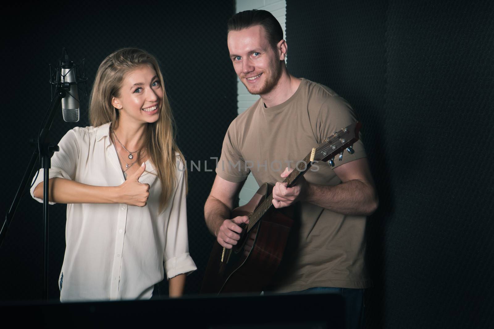 woman singer And man guitarist Caucasian people are practicing and Have fun laughing together in the sound recording studio. concept Artist audition for media, music, and performance produce
