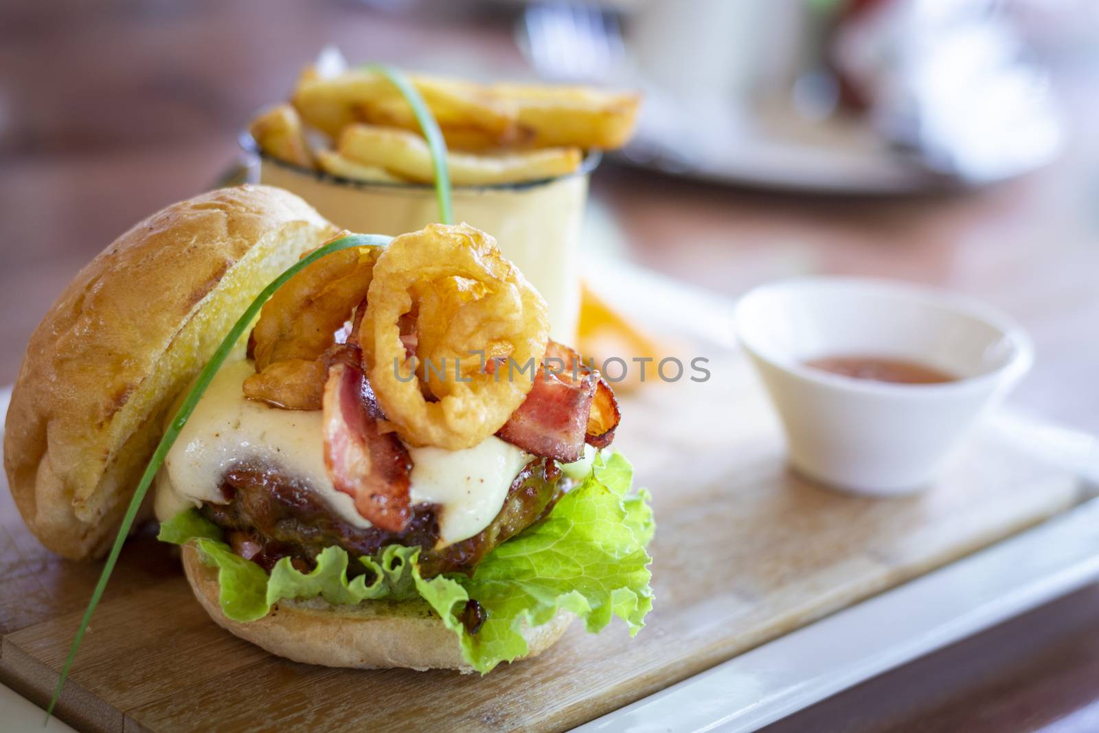 Tasty beef hamburger, with calamares, salad, bacon and egg and french fries. Selective focus.