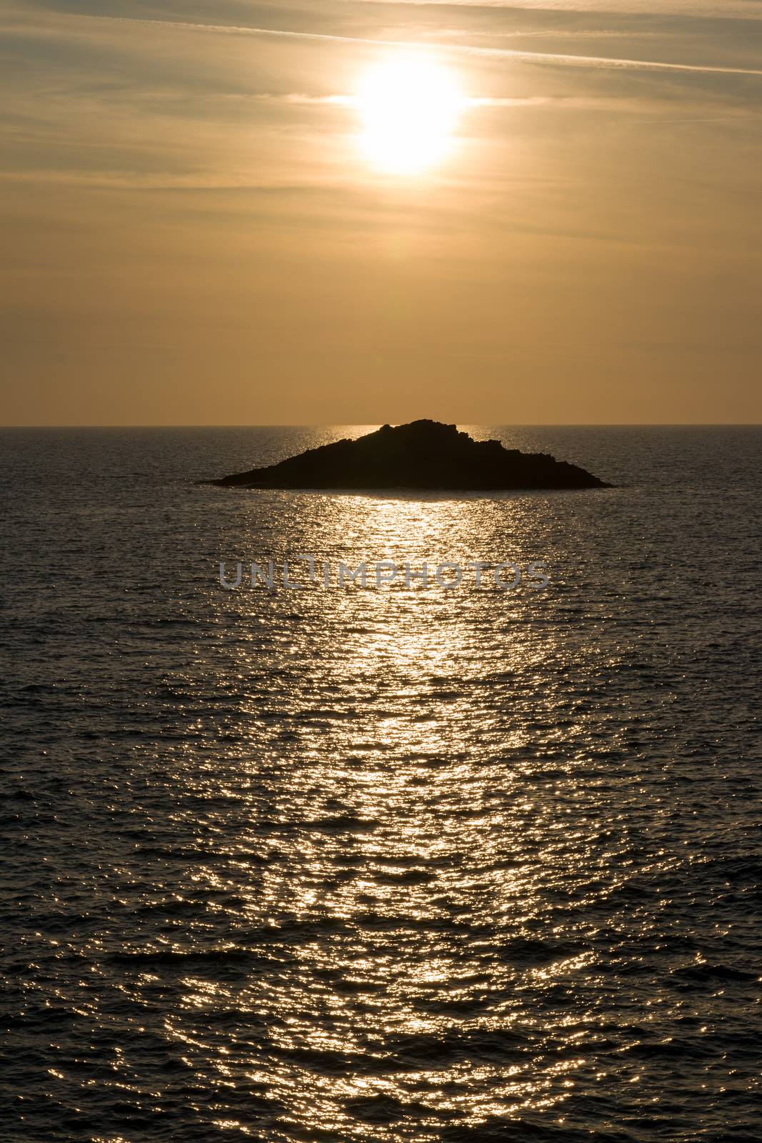 Ocean view with setting sun and sailboat on horizon, Quiberon, Brittany, France