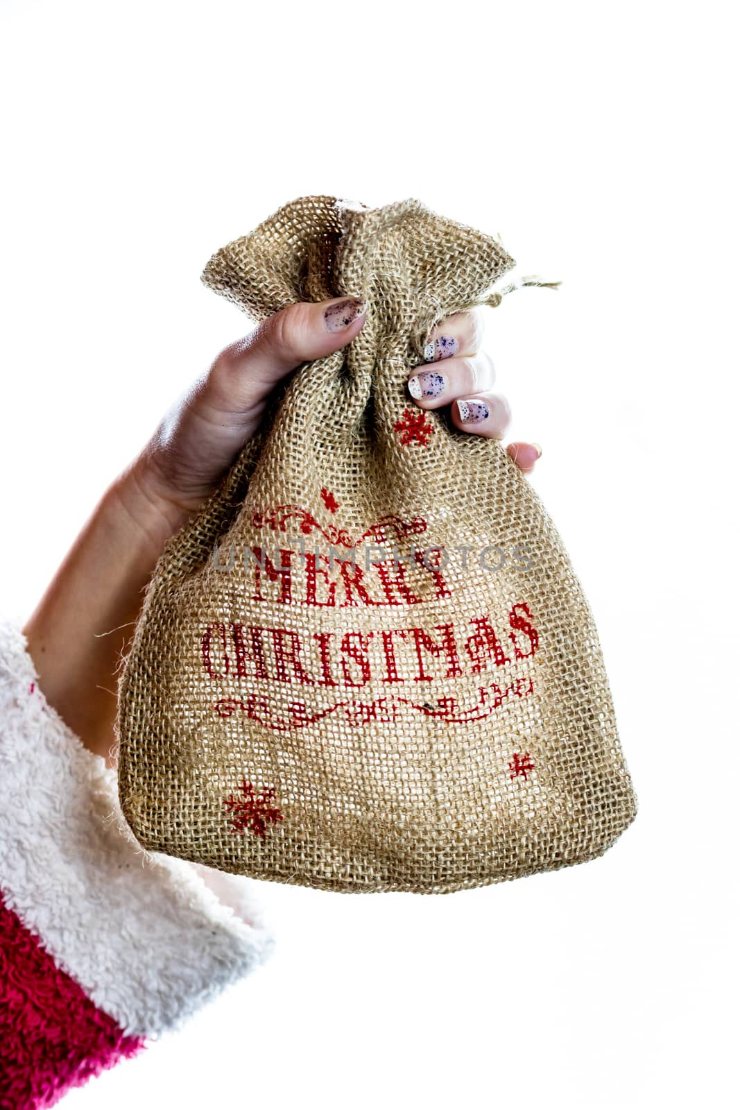 Hand holding Christmas burlap sack isolated on white background