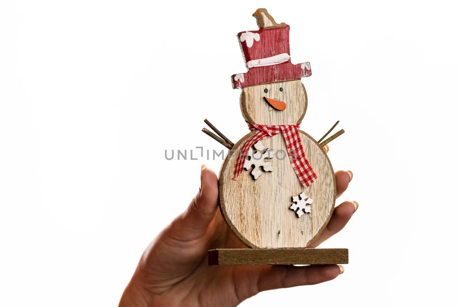 Hand holding Christmas snowman figurine isolated on white backgr by vladispas