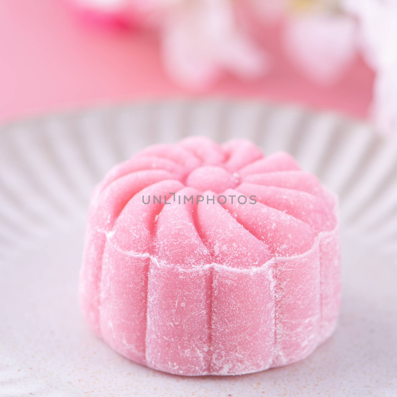 Colorful snow skin moon cake, sweet snowy mooncake, traditional savory dessert for Mid-Autumn Festival on pastel pale pink background, close up, lifestyle.