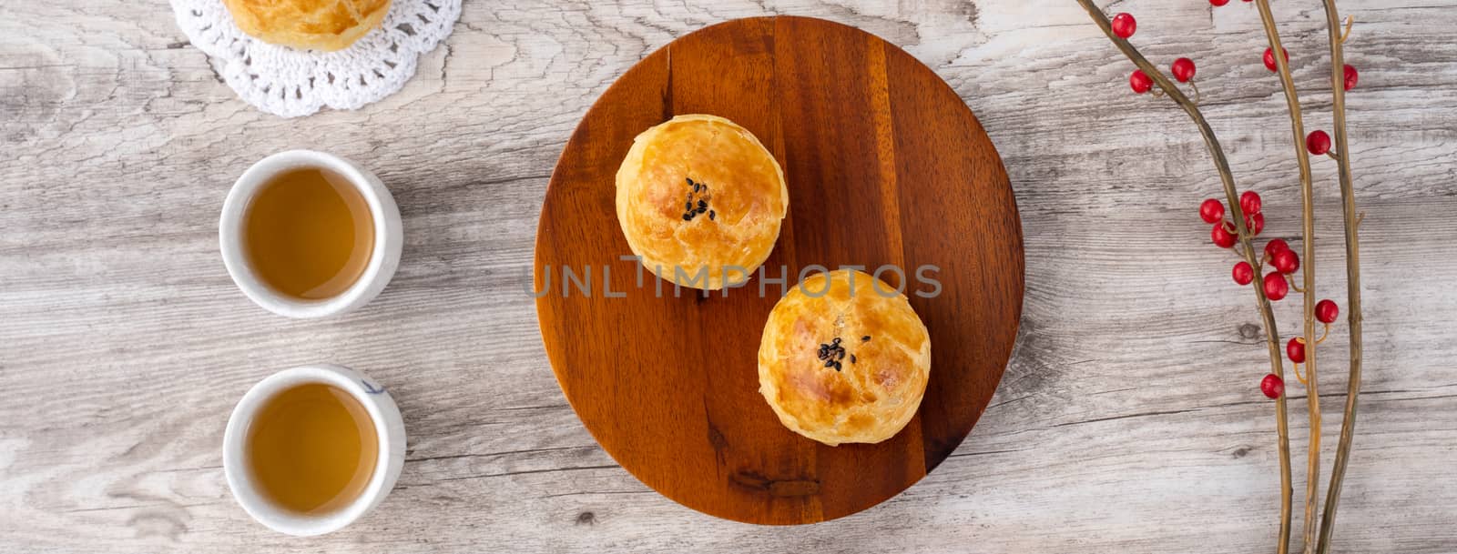 Moon cake yolk pastry, mooncake for Mid-Autumn Festival holiday, top view design concept on bright wooden table with copy space, flat lay, overhead shot