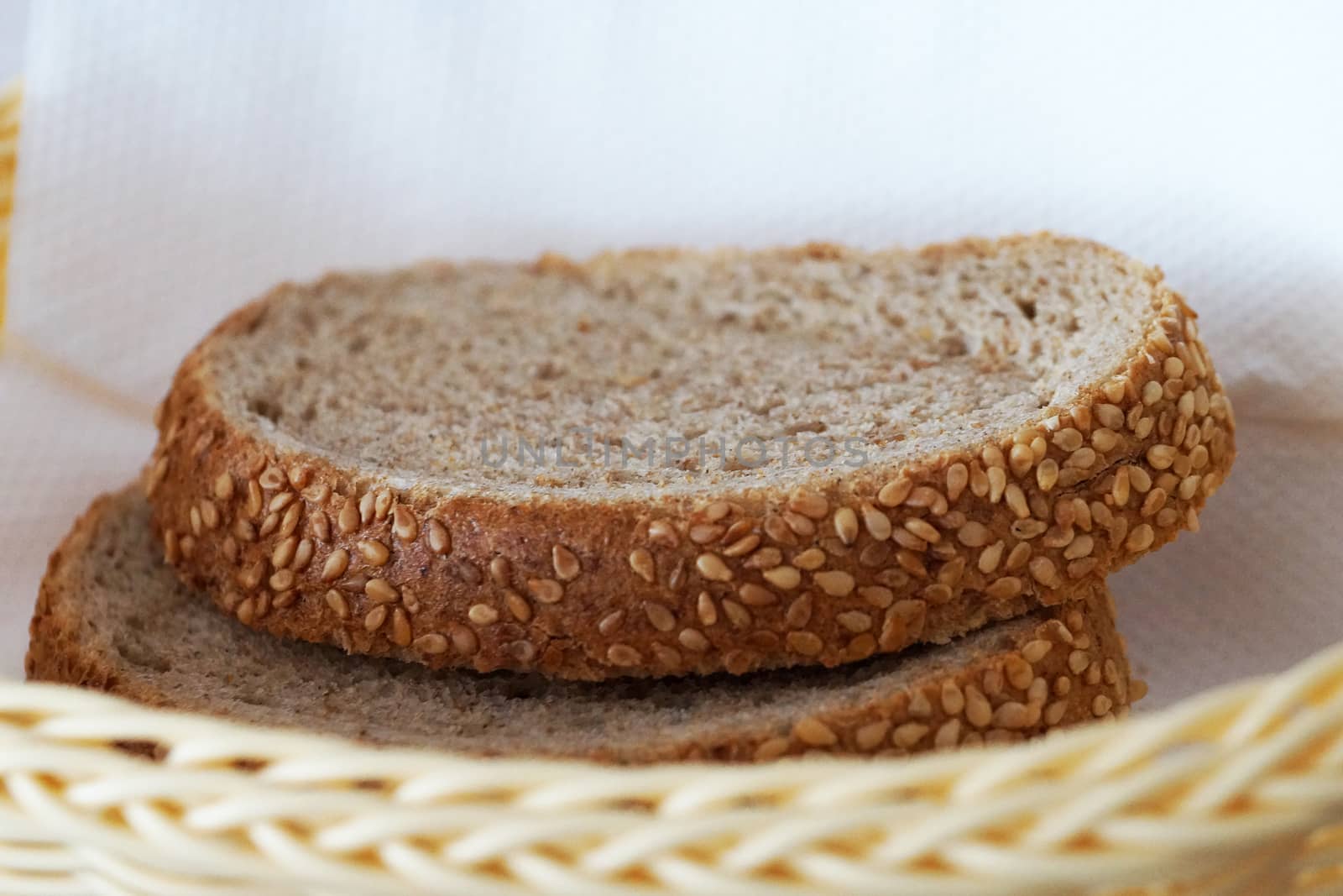 sliced bread in a wicker plate close up by Annado