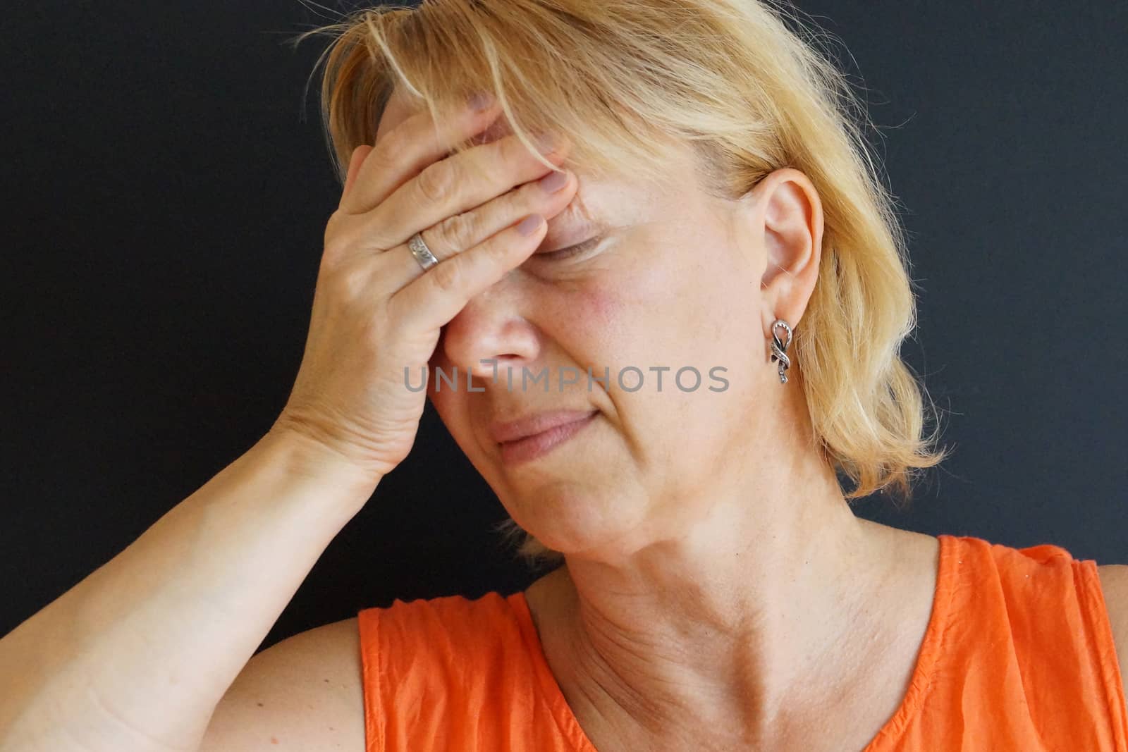 woman with closed eyes holding her sore head by Annado