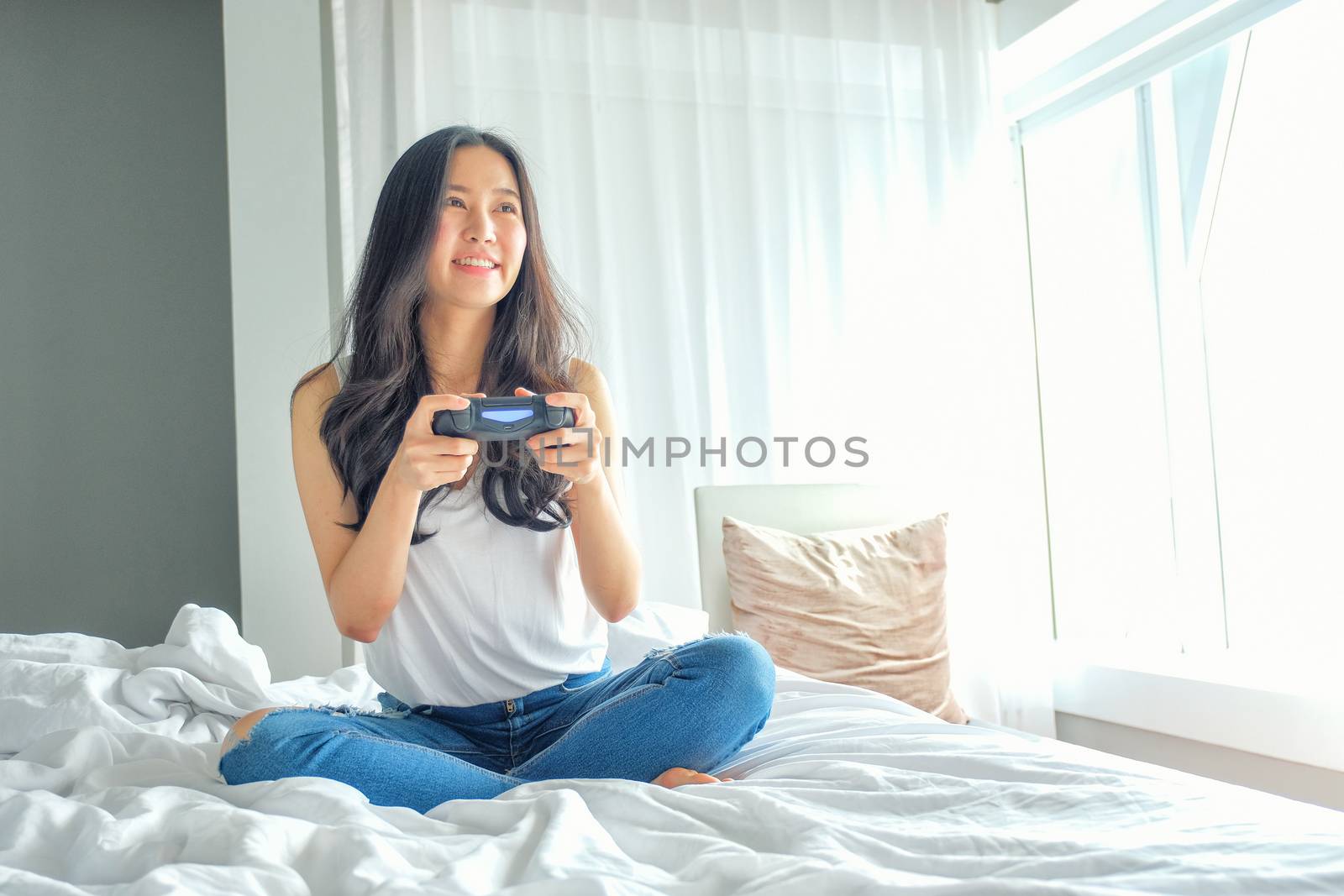 Beautiful girl playing video game on bed