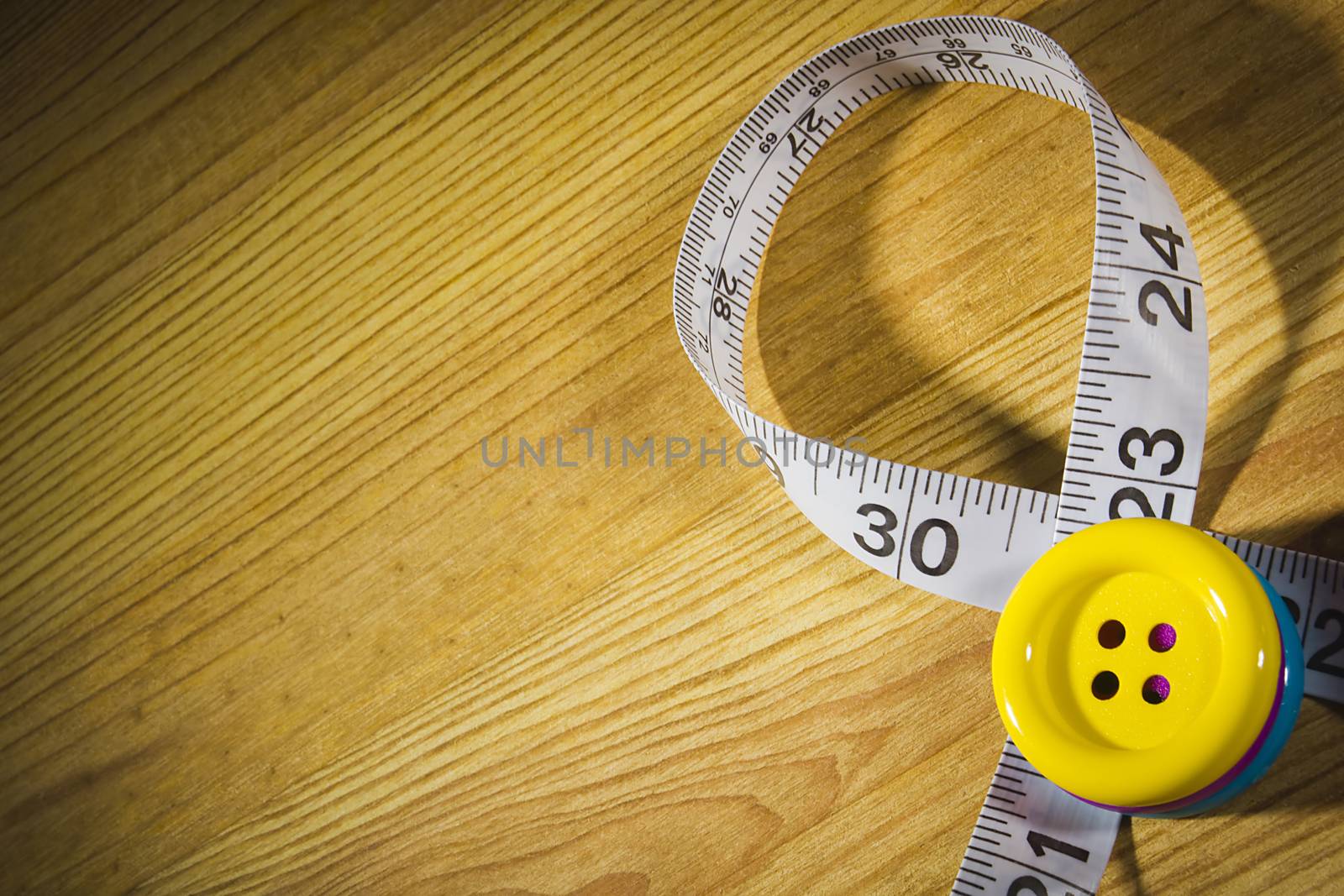Tailor meter and buttons on wooden table