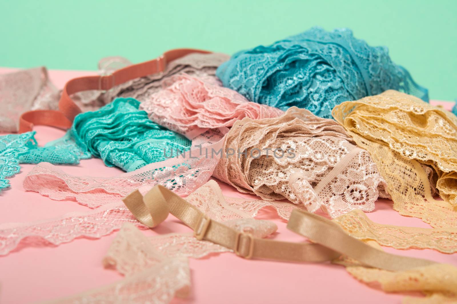 Abstract background with pile of color lace for Lingerie, panties, and bras on pink background. by polyats