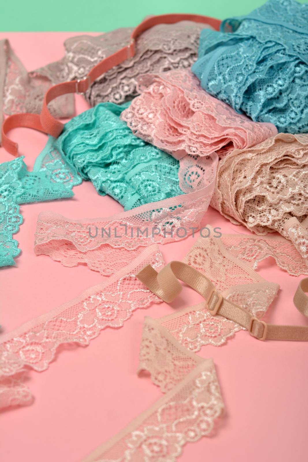 Abstract background with pile of color lace for Lingerie, panties, and bras on pink background. by polyats